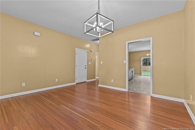 60 Hunters Way, Angier, NC 27501 - unfurnished room featuring visible vents, wood finished floors, baseboards, and a notable chandelier