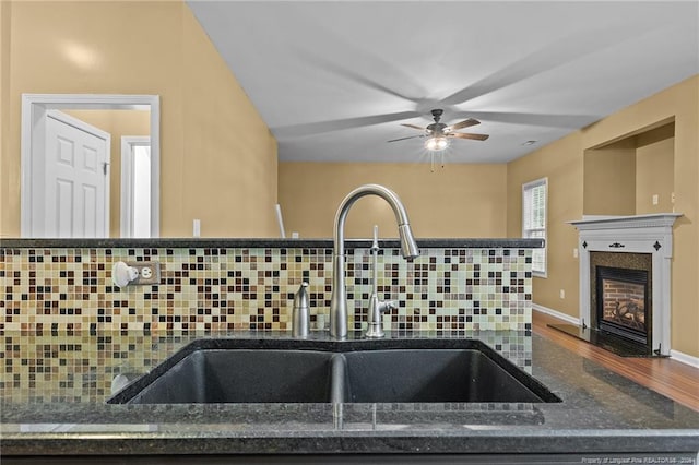 60 Hunters Way, Angier, NC 27501 - details featuring tasteful backsplash, ceiling fan, a sink, a fireplace with flush hearth, and dark stone counters