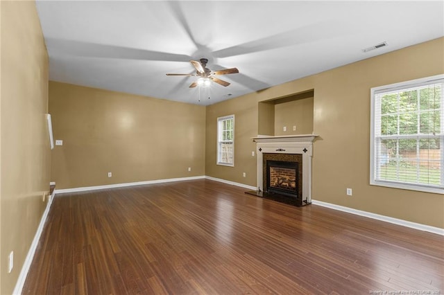60 Hunters Way, Angier, NC 27501 - unfurnished living room with a ceiling fan, a fireplace with raised hearth, baseboards, visible vents, and wood finished floors