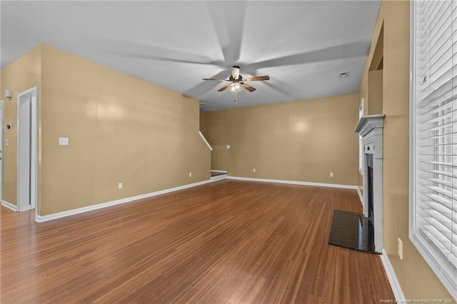 60 Hunters Way, Angier, NC 27501 - unfurnished living room with a ceiling fan, baseboards, a fireplace with flush hearth, and wood finished floors