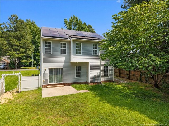 60 Hunters Way, Angier, NC 27501 - back of property with solar panels, a patio, a fenced backyard, and a standing seam roof