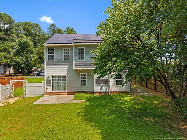 60 Hunters Way, Angier, NC 27501 - rear view of property with roof mounted solar panels, a fenced backyard, a standing seam roof, a patio area, and a metal roof
