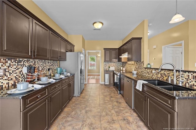 60 Hunters Way, Angier, NC 27501 - kitchen with dark brown cabinetry, backsplash, a peninsula, stainless steel appliances, and dark stone counters