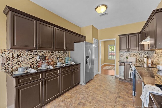 60 Hunters Way, Angier, NC 27501 - kitchen featuring stainless steel refrigerator with ice dispenser, dark brown cabinets, decorative backsplash, under cabinet range hood, and dark stone countertops
