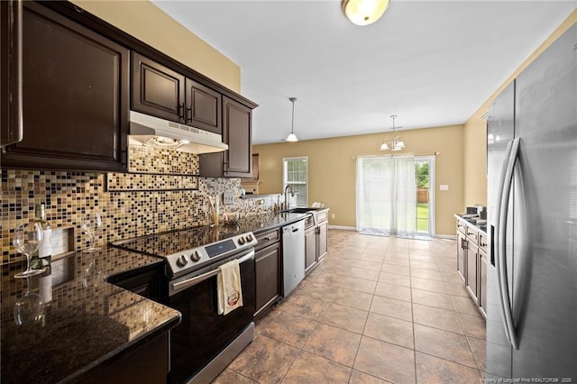 60 Hunters Way, Angier, NC 27501 - kitchen featuring appliances with stainless steel finishes, under cabinet range hood, dark brown cabinetry, backsplash, and dark stone countertops