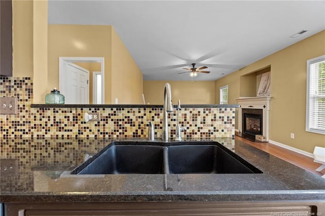 60 Hunters Way, Angier, NC 27501 - kitchen view of backsplash, ceiling fan, dark stone countertops, and a fireplace
