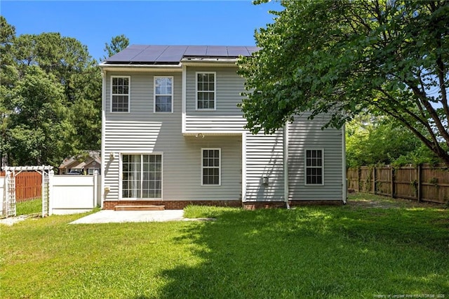 60 Hunters Way, Angier, NC 27501 - back of house featuring roof mounted solar panels, a fenced backyard, and a patio