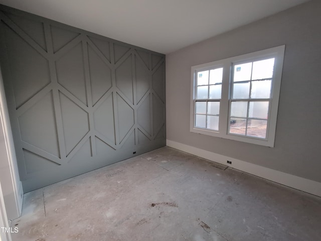 unfurnished room with baseboards