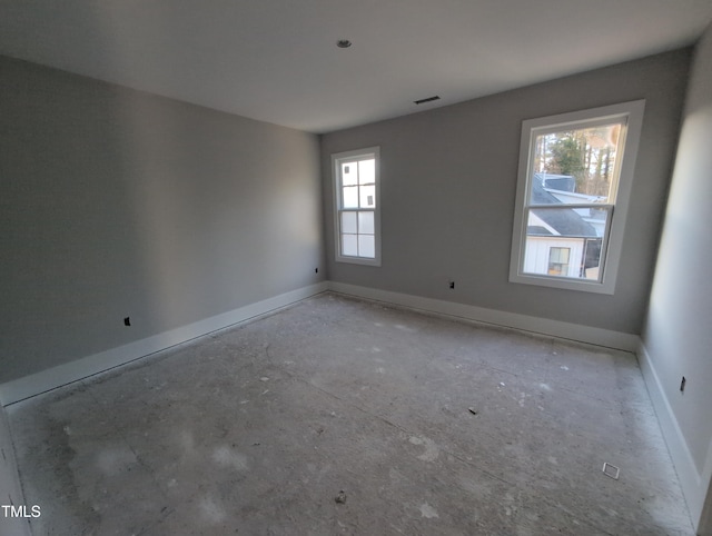 unfurnished room with visible vents and baseboards