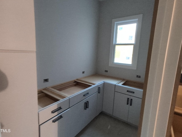 kitchen featuring white cabinetry, light countertops, and a sink