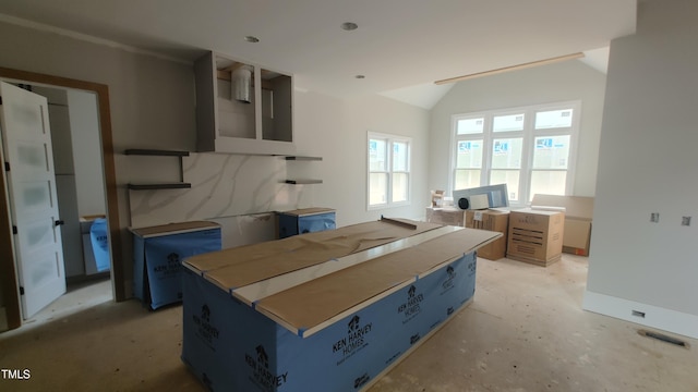 bedroom featuring lofted ceiling and concrete floors