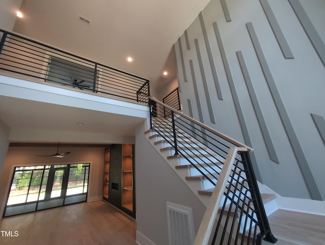 staircase with wood finished floors, ceiling fan, baseboards, visible vents, and recessed lighting