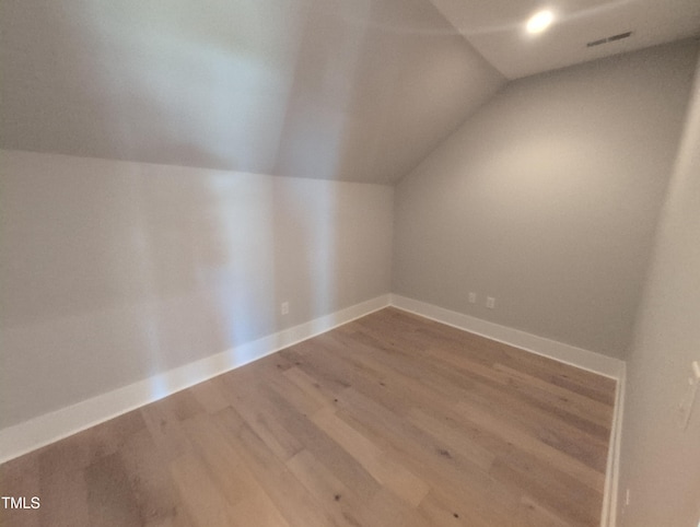 bonus room featuring vaulted ceiling, wood finished floors, and baseboards