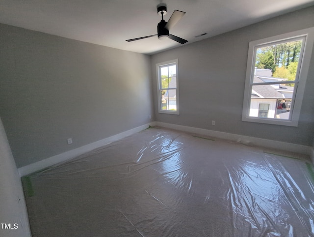 unfurnished room featuring ceiling fan, baseboards, concrete flooring, and visible vents