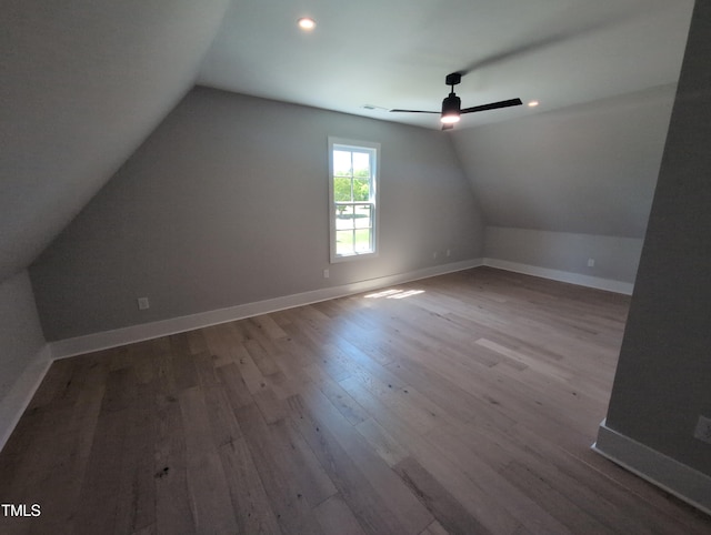 additional living space featuring lofted ceiling, a ceiling fan, wood finished floors, and baseboards