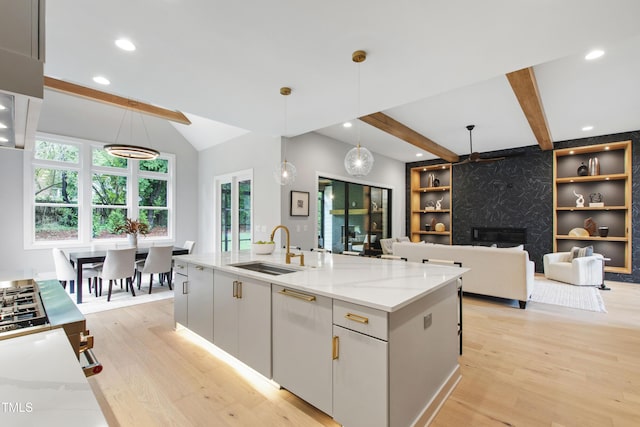 5812 Shawood Dr, Raleigh, NC 27609 - kitchen featuring light wood finished floors, a sink, light stone countertops, pendant lighting, and a fireplace
