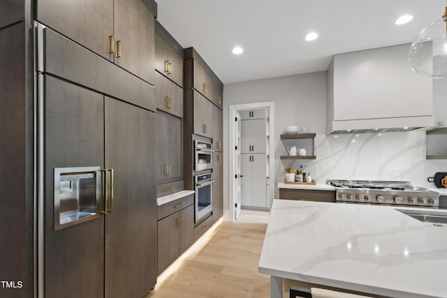 5812 Shawood Dr, Raleigh, NC 27609 - kitchen with light wood-style floors, light stone countertops, recessed lighting, paneled fridge, and custom exhaust hood