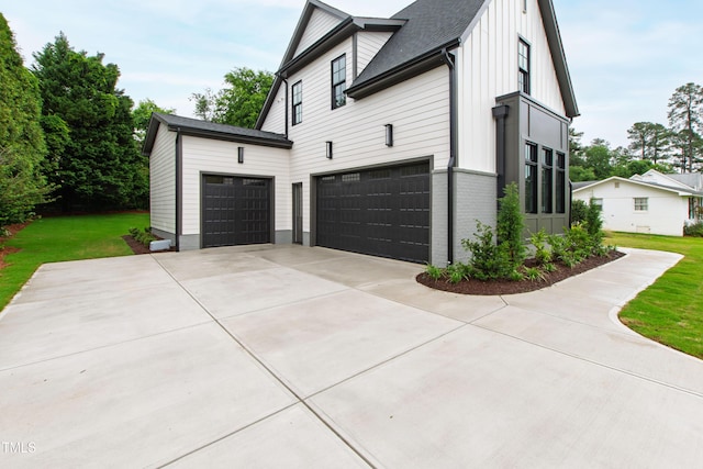 5812 Shawood Dr, Raleigh, NC 27609 - view of home's exterior featuring a garage, a lawn, concrete driveway, and brick siding