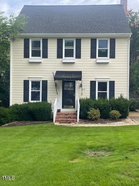 colonial inspired home with a front lawn