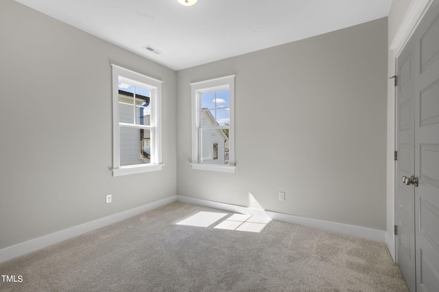 empty room with visible vents, baseboards, and carpet floors