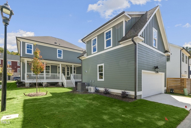 rear view of house with a garage, a lawn, central AC unit, and a porch