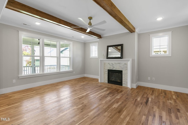 unfurnished living room featuring ceiling fan, hardwood / wood-style flooring, beamed ceiling, and ornamental molding