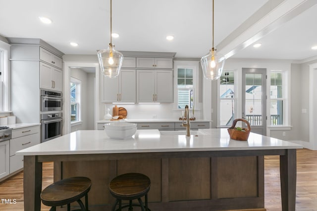 210 Colvard Farms Rd, Durham, NC 27713 - kitchen with gray cabinetry, a kitchen breakfast bar, light countertops, and a sink