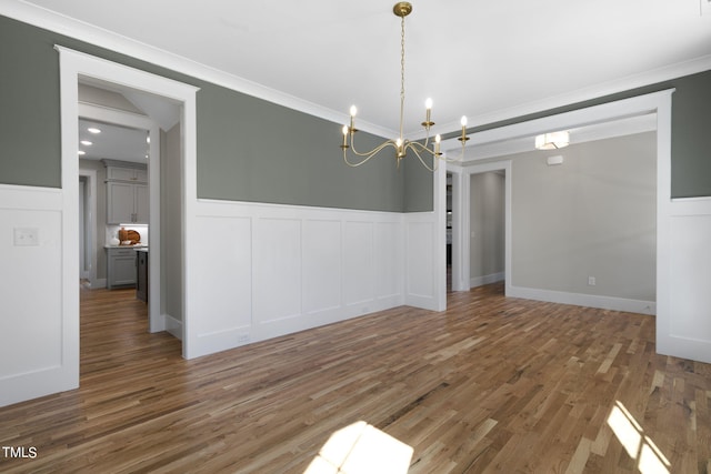 210 Colvard Farms Rd, Durham, NC 27713 - unfurnished dining area featuring an inviting chandelier, a wainscoted wall, a decorative wall, ornamental molding, and wood finished floors
