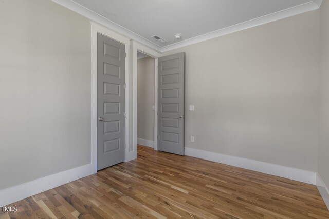 spare room featuring crown molding and hardwood / wood-style floors