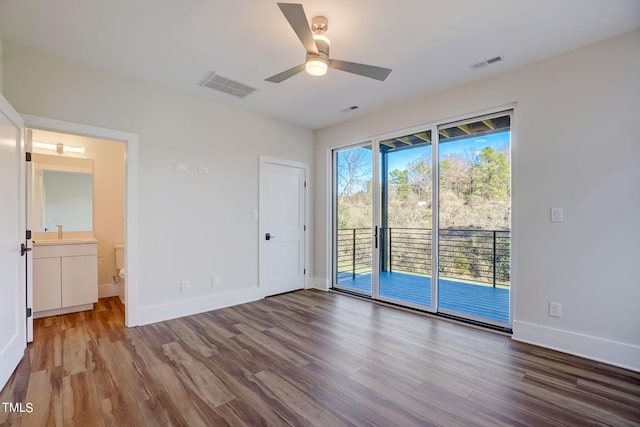 interior space with hardwood / wood-style flooring, multiple windows, access to outside, and ensuite bathroom