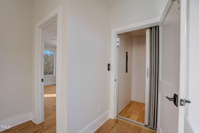 hallway with light hardwood / wood-style floors