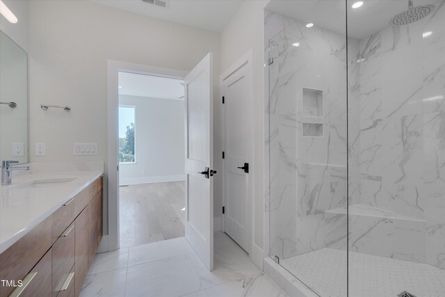 bathroom featuring tiled shower and vanity