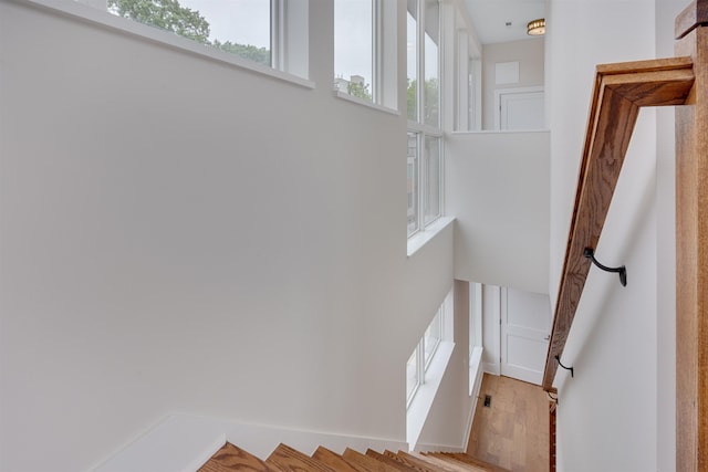 stairs with a towering ceiling and hardwood / wood-style floors