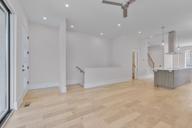 unfurnished living room featuring light hardwood / wood-style flooring and ceiling fan