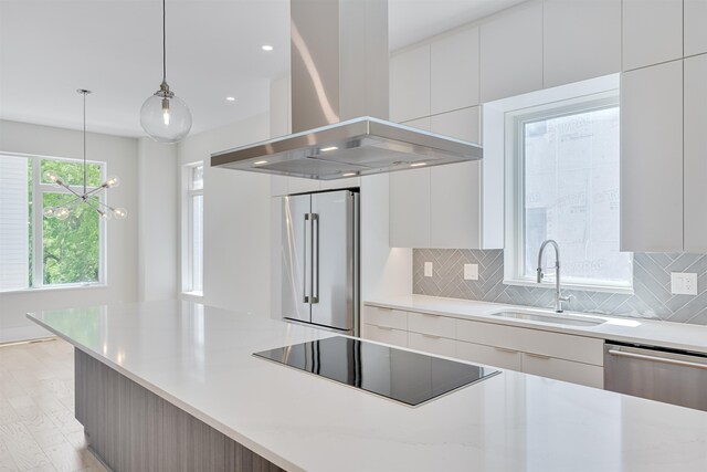 kitchen featuring stainless steel appliances, sink, white cabinets, and island exhaust hood