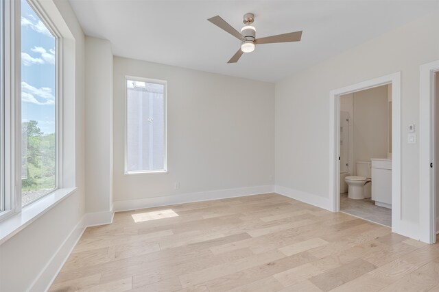 interior space featuring ensuite bath, light hardwood / wood-style flooring, and ceiling fan