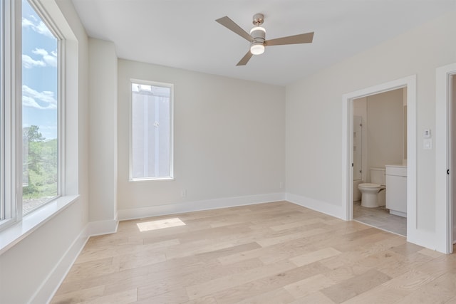 unfurnished bedroom with light hardwood / wood-style floors, ceiling fan, and ensuite bathroom