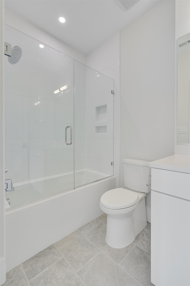 full bathroom featuring vanity, tile patterned flooring, bath / shower combo with glass door, and toilet