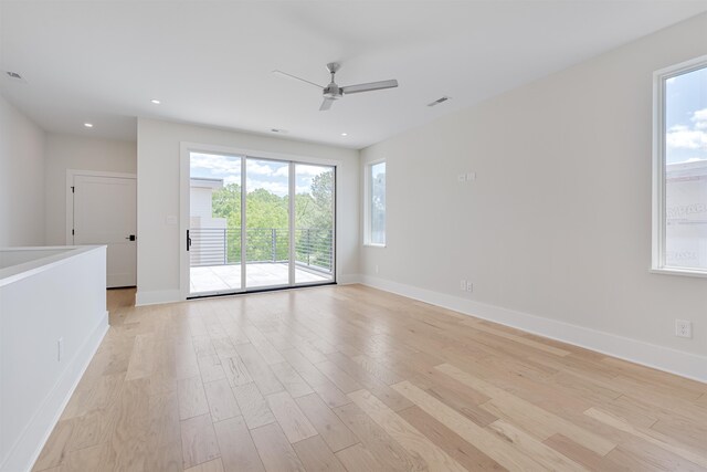 empty room with ceiling fan, light hardwood / wood-style floors, and a healthy amount of sunlight