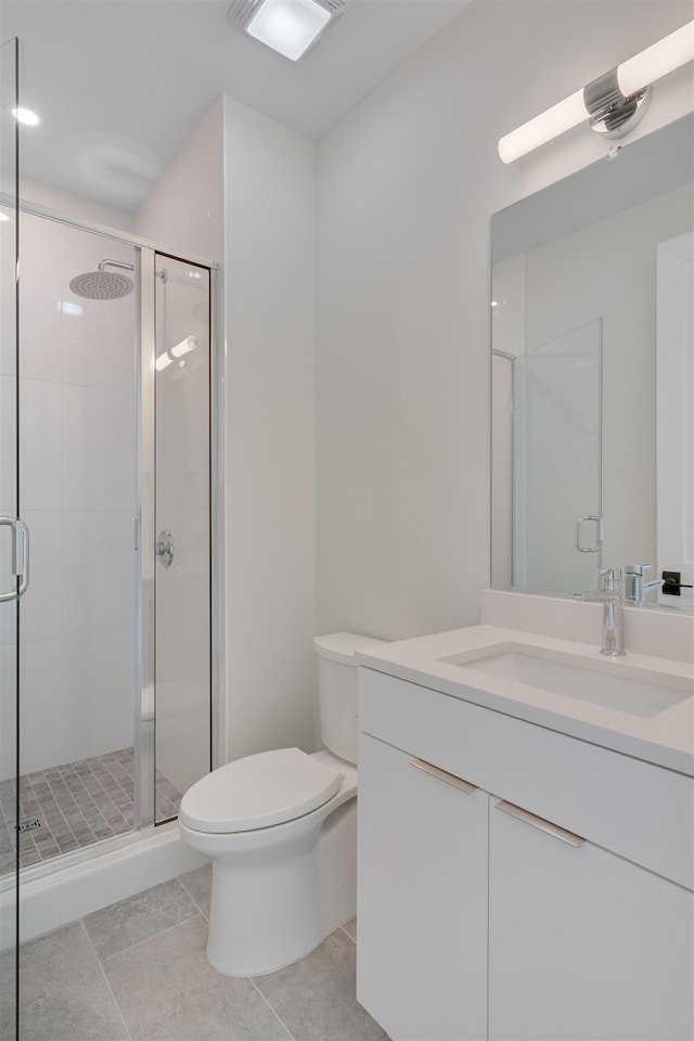 bathroom featuring tile patterned floors, vanity, toilet, and a shower with shower door