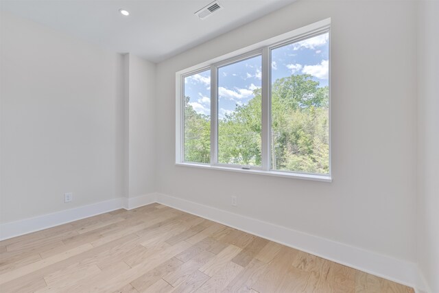 spare room with light wood-type flooring and a healthy amount of sunlight