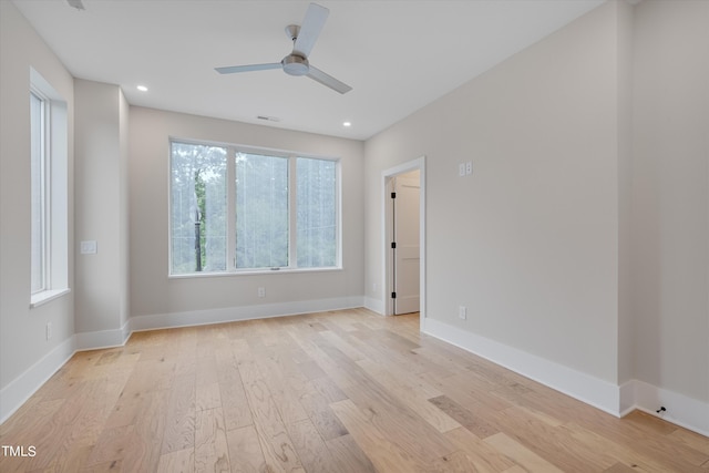 empty room with ceiling fan and light hardwood / wood-style flooring