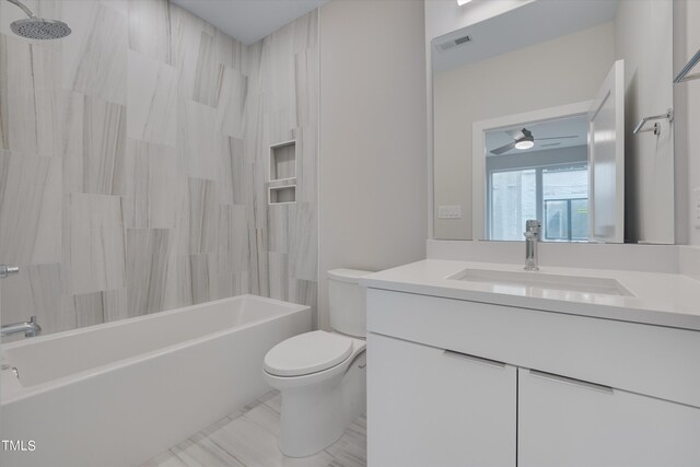 full bathroom with tiled shower / bath combo, vanity, toilet, and ceiling fan