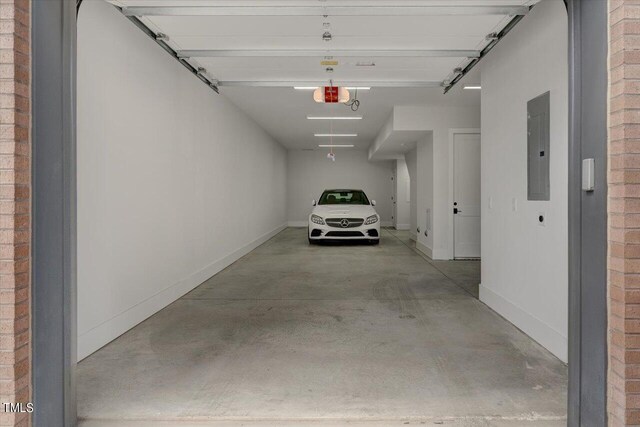 garage with a garage door opener and electric panel