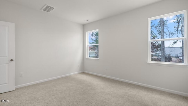 carpeted spare room with baseboards and visible vents