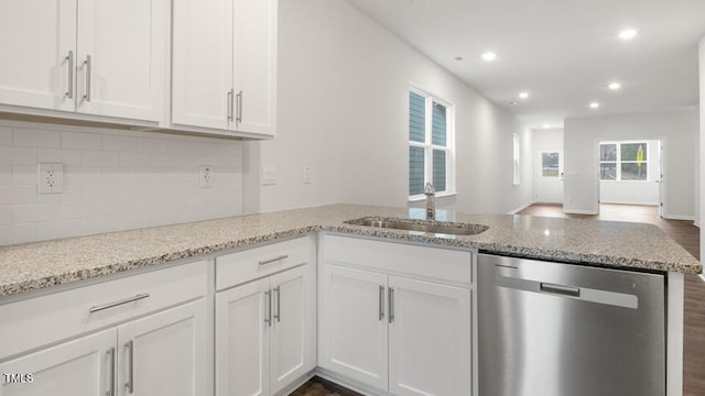 kitchen featuring a sink, white cabinetry, light stone counters, and stainless steel dishwasher