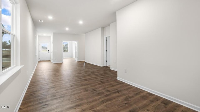 unfurnished living room featuring baseboards, dark wood-style flooring, and recessed lighting