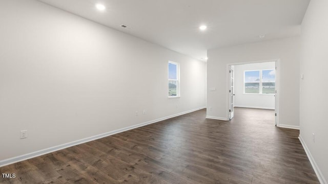 spare room with baseboards, dark wood finished floors, and recessed lighting