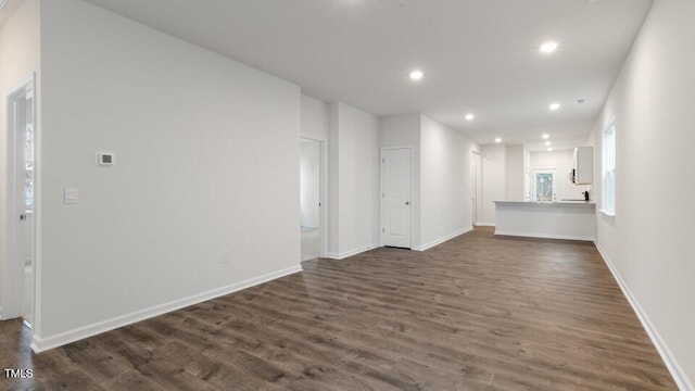 spare room with dark wood-type flooring, recessed lighting, and baseboards