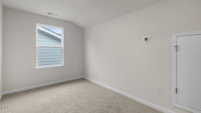 carpeted empty room featuring lofted ceiling, visible vents, and baseboards